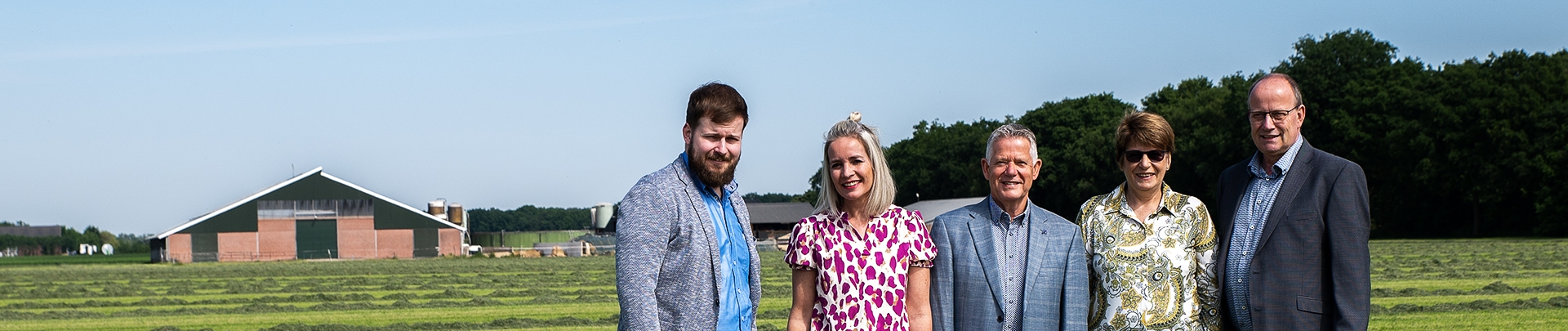 Het team van De Rijck & Van de Ven in een weiland met een boerderij op de achtergrond.